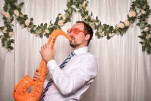 Gast in der Fotobox mit aufblasbarem Saxofon