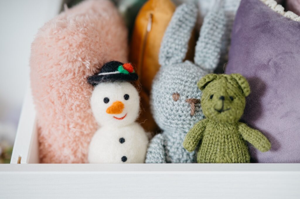 Gestrickte Kuscheltiere im Fotostudio in Denkendorf: Schneemann, Hase und Bär vor weichen Kissen